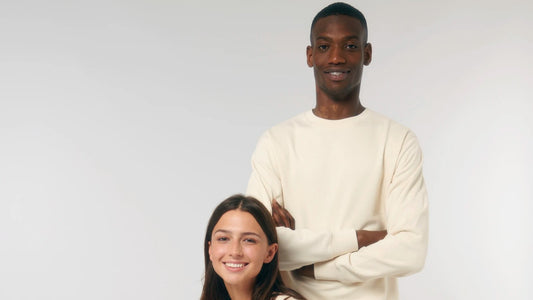 Twee collega's in een creme sweater van biologisch katoen, klaar voor een klein logo op de borst